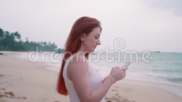 年轻的女游客在海边为日落拍照视频的预览图