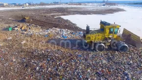 空中飞行垃圾填埋车在城市垃圾填埋场用一个凸起的刀片移动垃圾垃圾倾倒垃圾4K视频的预览图