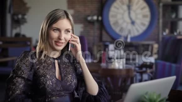一个漂亮的女商人和她的手机伙伴交谈一个年轻的女人在一家舒适的咖啡馆里安排了一次会面在那里她视频的预览图