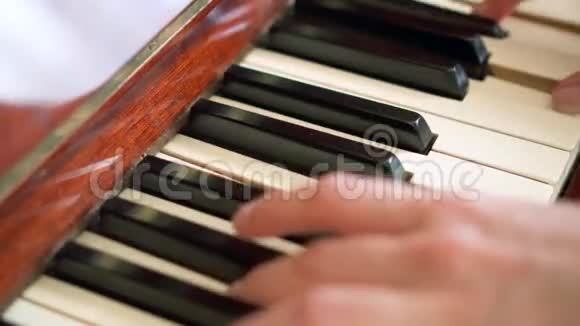 女性手指在复古钢琴键盘上弹键浅的景深专注于钢琴键视频的预览图