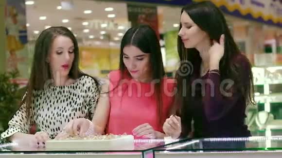 三个女朋友在购物中心看戒指和试穿的肖像视频的预览图
