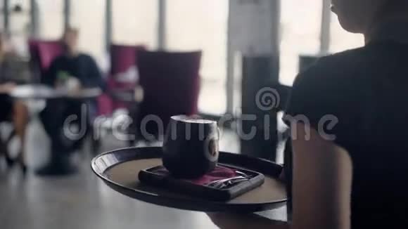 侍者端着一个大卡布奇诺杯放在托盘上这对年轻夫妇在一家餐馆里做开胃酒视频的预览图