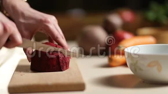 女人用手在木板上切甜菜视频的预览图