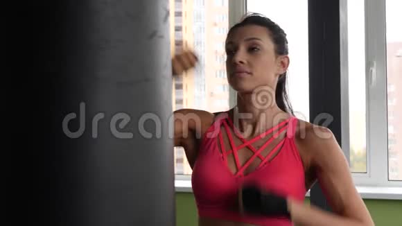 魅力跆拳道混合赛女子训练沙袋在健身工作室猛力慢动作视频的预览图