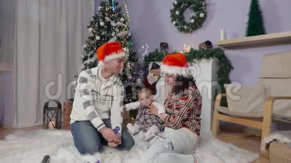 戴着圣诞老人帽子带着孩子的家庭会炸裂视频的预览图