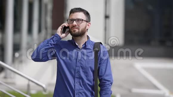 经理在办公楼的院子里街上一个男人在打电话视频的预览图