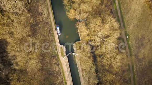 冬天的树木围绕着英国的运河锁和驳船视频的预览图