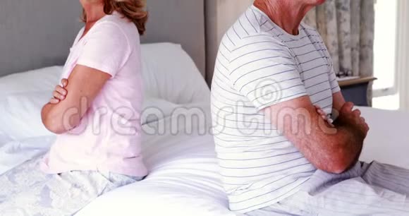 令人不安的老夫妇背靠背坐在床上视频的预览图