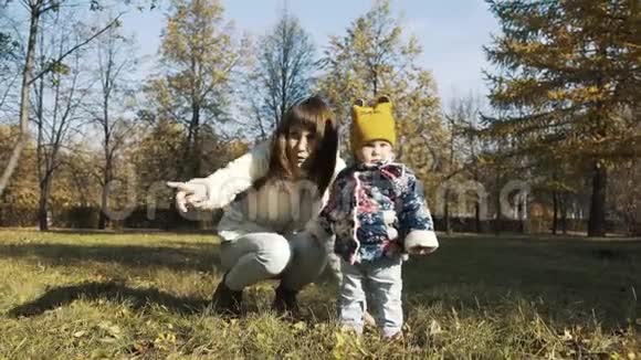 伟大的时髦年轻母亲和他的女儿们穿着漂亮的衣服在公园散步视频的预览图