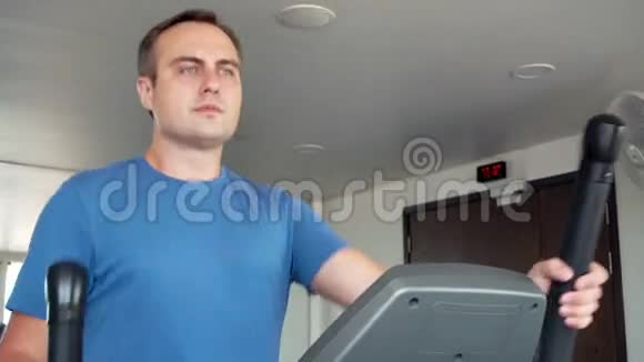 健美运动积极的年轻人在健身房锻炼椭圆教练锻炼视频的预览图