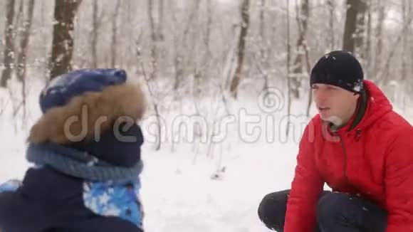 可爱的孩子们和爸爸在雪球里玩视频的预览图
