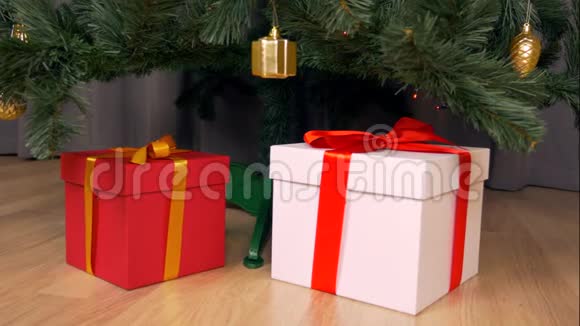 多利摄像机沿着圣诞树移动树下的礼物盒上有金色的蝴蝶结准备圣诞假期视频的预览图