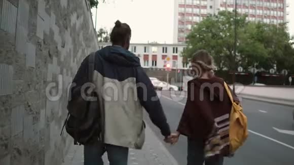 年轻漂亮的夫妇带着背包晚上在交通路附近散步男人和女人在一起视频的预览图