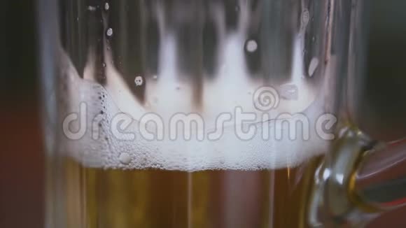 闭合桌子上有一个空杯子里面倒着泡沫啤酒视频的预览图