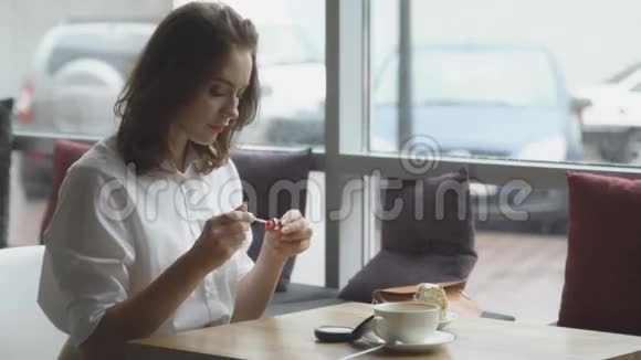 商务女性在咖啡厅午休后清爽的化妆女孩画嘴唇视频的预览图