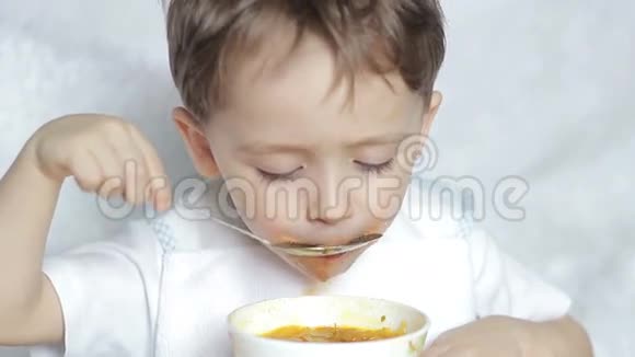 男孩独自用勺子吃汤视频的预览图
