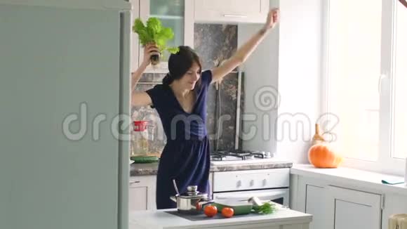 在家厨房做饭的时候有趣的女人会用绿生菜跳舞视频的预览图