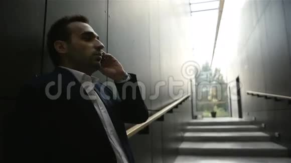 商人站在大楼里用手机说话视频的预览图