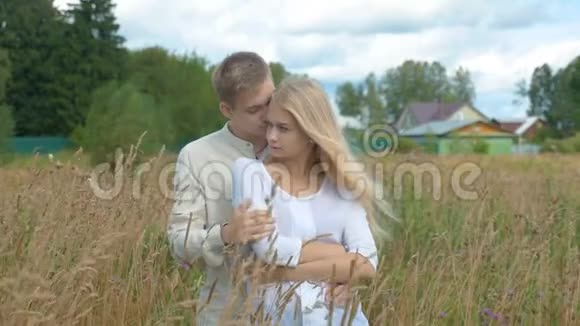 一个漂亮的金发女孩和她的男朋友在麦田上拥抱视频的预览图