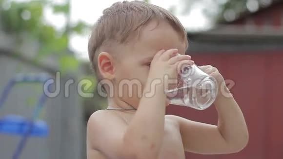 男孩从透明的杯子里喝水视频的预览图