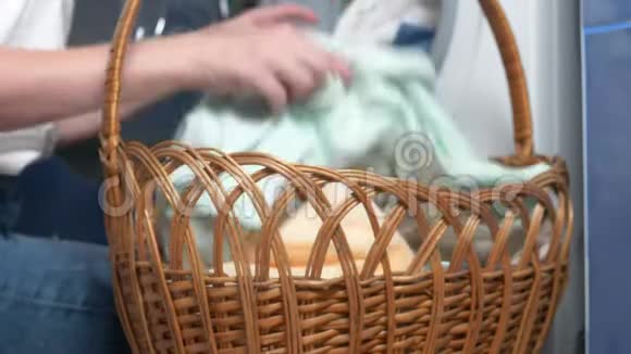 特写镜头不可辨认的女人把洗衣篮里的布放在洗衣机里视频的预览图