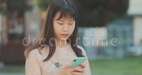 年轻的女商人在外面使用智能手机视频的预览图