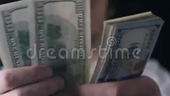 一个商人手数着一百美元钞票的特写镜头视频的预览图