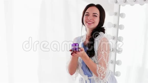 漂亮的女人完美的皮肤展示紫罗兰色天然霜专业的皮肤护理视频的预览图