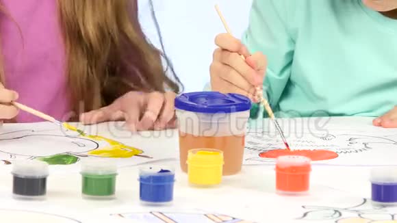 小孩子借助画笔和颜料装饰图画他们喜欢它闭合白色背景视频的预览图