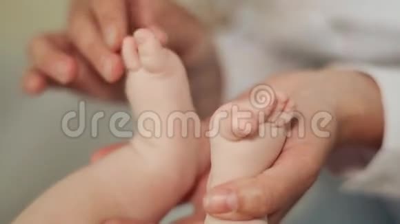 妈妈双手轻轻地抚摸着宝宝的小脚视频的预览图