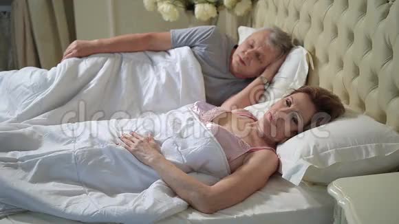 一位躺在床上伸懒腰醒过来的老妇人视频的预览图