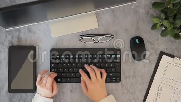 在最上面的女人手是在显示器前面的键盘上打字的视频的预览图