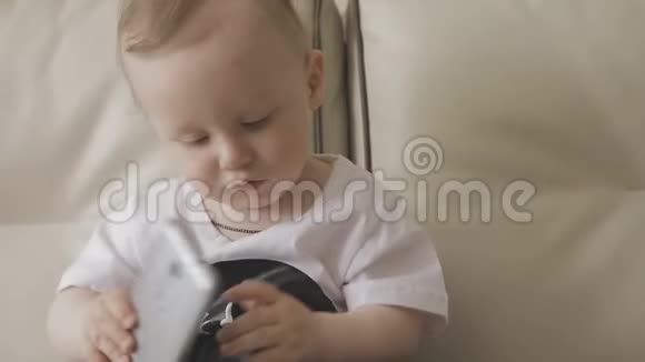 一个小孩子在玩智能手机家庭视频的预览图