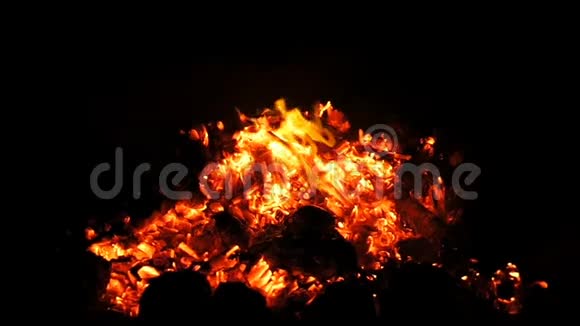 一团闪闪发光的火和红色的煤焦在夜间的海面上视频的预览图