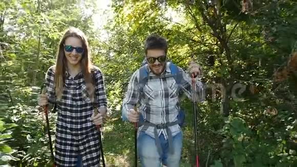 带背包的年轻夫妇在森林里旅游及远足概念视频的预览图