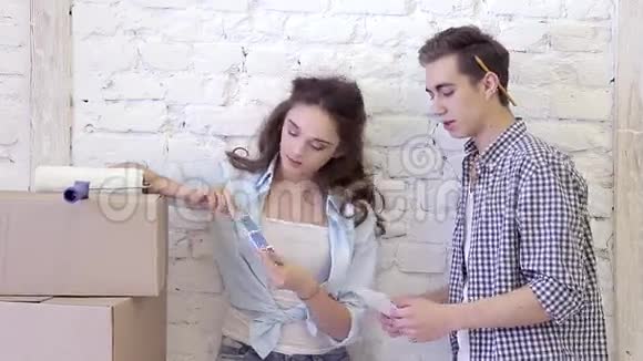 一对年轻夫妇的搬迁和修理他们选择墙的颜色视频的预览图