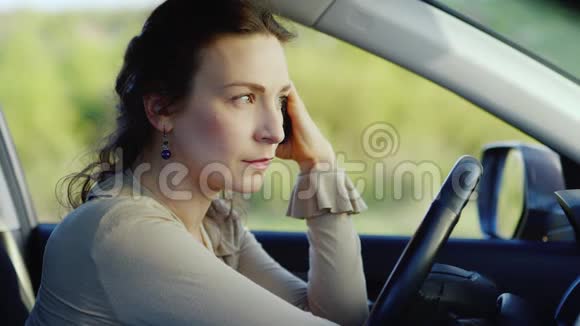抑郁症中年妇女的肖像他手里拿着电话在车里痛苦概念视频的预览图
