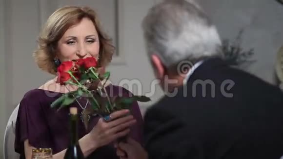 微笑的高级女人接受男人的鲜花视频的预览图