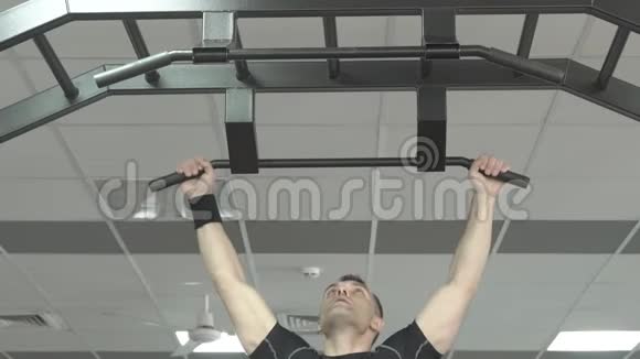 运动员肌肉健身男模在健身房的水平杆上拉起视频的预览图