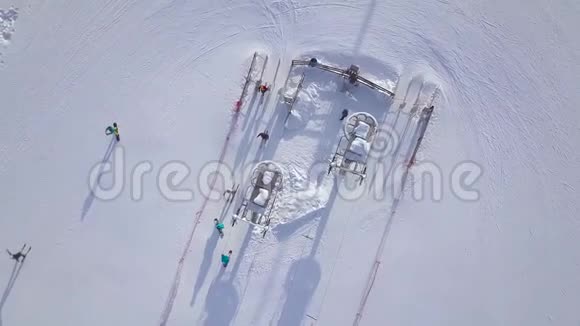 滑雪电梯在冬季度假村运输滑雪者和滑雪板在雪山无人驾驶飞机视图人们在雪地上滑雪视频的预览图
