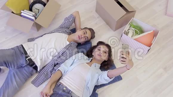 美丽的年轻夫妇在搬到新家后放松和自拍视频的预览图