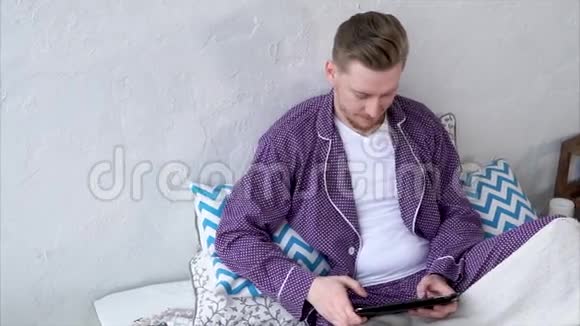 有平板电脑的人在社交网络上和朋友聊天在睡衣里视频的预览图