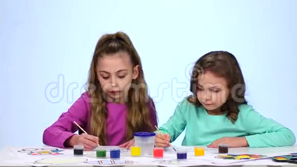 孩子们画一幅画用水在玻璃杯里蘸一把刷子快关门白色背景时间流逝视频的预览图
