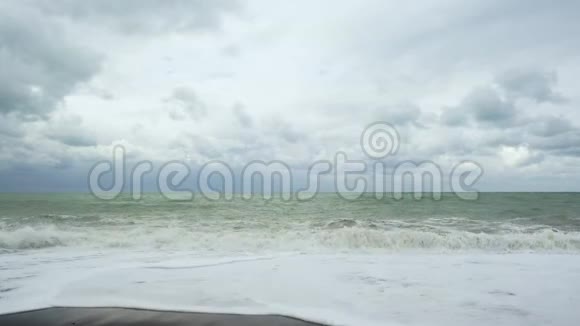 泡沫巨浪卷起鹅卵石滩视频的预览图