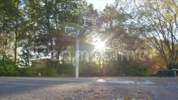 秋天的篮球场和镜头弗莱相机从左边篮球出现在图片中视频的预览图