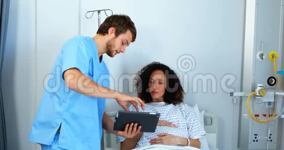 医生向孕妇提供数码平板电脑的医疗报告视频的预览图