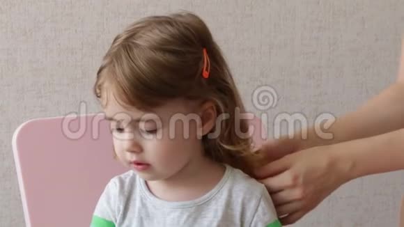 女人在家给女儿梳头概念幸福家庭视频的预览图