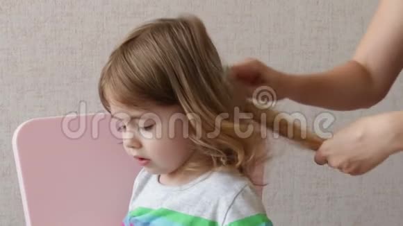 女人在家给女儿梳头概念幸福家庭视频的预览图