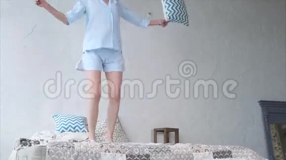 睡衣里的快乐女人在床上跳着笑视频的预览图