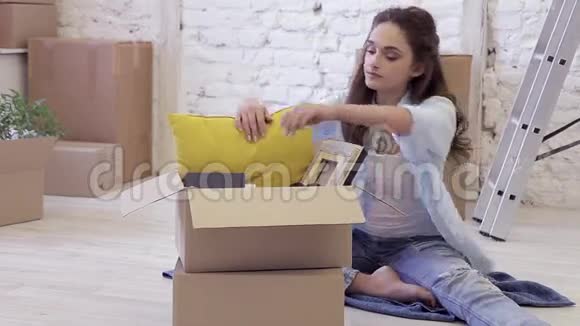 美丽的年轻女子打开盒子而她的丈夫带来另一个盒子视频的预览图